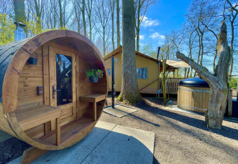 Zona de bienestar al aire libre en la tienda safari Glamphuys Ultra Wellness con sauna y jacuzzi en Buitengoed Ruysbos.