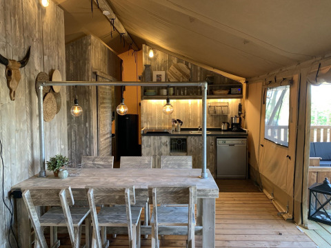 Rustiek safaritentinterieur bij Glamphuys Ultra Wellness, Buitengoed Ruysbos, Nederland met eetruimte en keuken.
