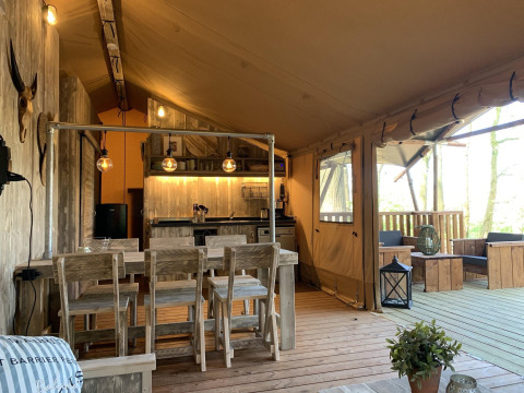 Interior de la tienda safari Glamphuys Ultra Wellness en Buitengoed Ruysbos, Países Bajos, con muebles rústicos.