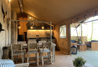 Intérieur de la tente safari Glamphuys Ultra Wellness à Buitengoed Ruysbos, Pays-Bas, avec mobilier en bois.