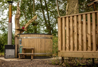 Bañera de madera al aire libre junto a tienda safari, Glamphuys Ultra Wellness, Buitengoed Ruysbos, Países Bajos.