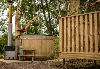 Bañera de madera al aire libre junto a tienda safari, Glamphuys Ultra Wellness, Buitengoed Ruysbos, Países Bajos.