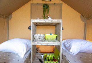 Interior of a safari tent at Marina Parcs Almere, Netherlands, with twin beds and kitchen essentials.
