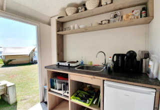 Pequeña cocina en una tienda safari en Marina Parcs Almere, Países Bajos, con vista al exterior y tienda.
