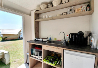 Pequeña cocina en una tienda safari en Marina Parcs Almere, Países Bajos, con vista al exterior y tienda.