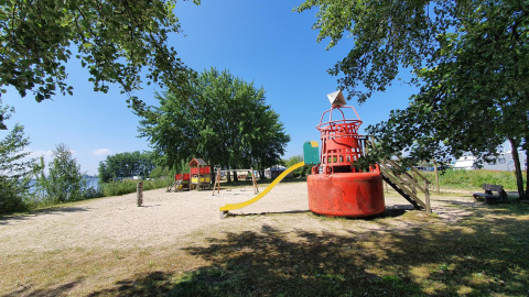 Parque infantil en tienda safari en Marina Parcs Almere, Países Bajos, con tobogán y área de arena.