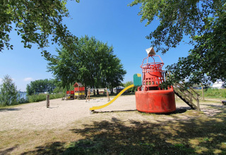 Parque infantil en tienda safari en Marina Parcs Almere, Países Bajos, con tobogán y área de arena.