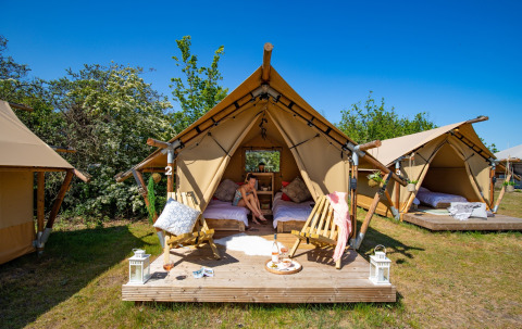 Safari-Zelte bei Marina Parcs Almere, Niederlande, mit Holzterrasse, Lounge-Sesseln und sonnigem Wetter.