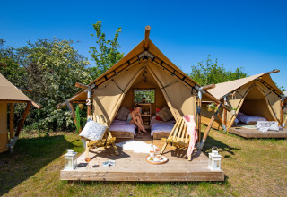 Safari-Zelte bei Marina Parcs Almere, Niederlande, mit Holzterrasse, Lounge-Sesseln und sonnigem Wetter.