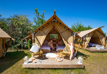 Safari tent setup at Marina Parcs Almere, Netherlands, featuring cozy seating, beds, and outdoor relaxation.