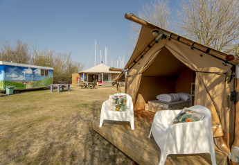 Safari-Zelt bei Marina Parcs Almere in den Niederlanden mit Stühlen und Blick auf weitere Campingbereiche.