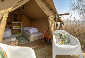 Innenaufnahme eines Safarizelts mit zwei Betten und Stühlen bei Marina Parcs Almere in den Niederlanden.