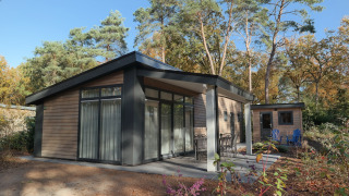 Modernes Holzchalet Forest park chalet 8p im Ferienpark De Kleine Belties, umgeben von Wäldern in den Niederlanden.