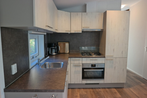 Cucina moderna nel Forest park chalet 8p al Holiday park De Kleine Belties nei Paesi Bassi, con forno e piano cottura.