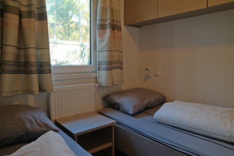 Kamer met twee eenpersoonsbedden en grijs beddengoed in Forest park chalet 8p, De Kleine Belties.