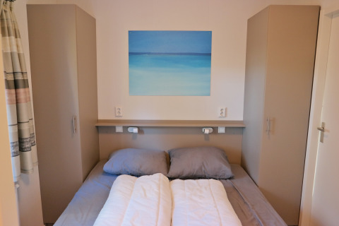 Camera da letto del Forest park chalet 8p, Holiday park De Kleine Belties, Paesi Bassi, con letto doppio.