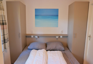 Camera da letto del Forest park chalet 8p, Holiday park De Kleine Belties, Paesi Bassi, con letto doppio.