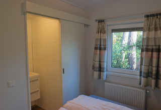 Dormitorio en Forest park chalet 8p con vista al bosque y acceso al baño, Holiday park De Kleine Belties, Países Bajos.