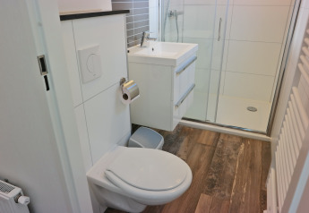 Modern bathroom with toilet, sink, and shower at Forest park chalet 8p, Holiday park De Kleine Belties, Netherlands.