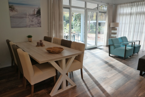 Bright interior of Forest park chalet 8p at Holiday park De Kleine Belties, featuring dining and lounge area.