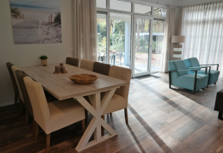 Bright interior of Forest park chalet 8p at Holiday park De Kleine Belties, featuring dining and lounge area.