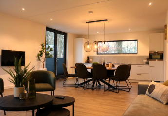 Sala de estar y cocina modernas en Forest Cube, Holiday Park BreeBronne, Países Bajos, con luz natural.