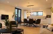 Modernes Wohnzimmer und Küche im Forest Cube im Holiday Park BreeBronne in den Niederlanden mit hellem Licht.