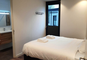 Chambre moderne au Forest Cube, Holiday Park BreeBronne aux Pays-Bas, avec lit double et salle de bain.