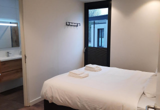Camera moderna al Forest Cube presso Holiday Park BreeBronne, Paesi Bassi, con letto matrimoniale e bagno.