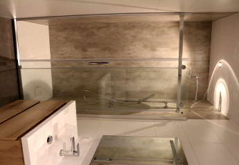 Salle de bain moderne au Forest Cube du Holiday Park BreeBronne avec baignoire et lavabo en bois.