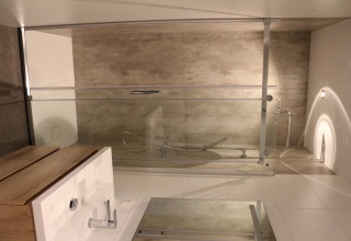 Modernes Badezimmer im Forest Cube im Holiday Park BreeBronne mit Badewanne und Holzwaschtisch.