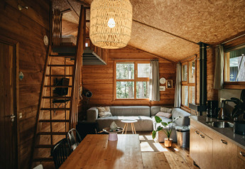 Accogliente interno di tenda safari Youpi! Lodge, Beerze Bulten, Paesi Bassi, con arredo in legno e soppalco.