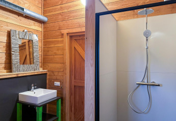 Interno del bagno nella tenda safari Youpi! Lodge a Beerze Bulten, Paesi Bassi, con doccia e lavabo.