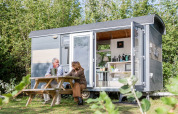 To personer sidder udenfor en lille vogn kaldet Tiny Wagon på Marina Parcs Almere i Holland.