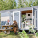 Deux personnes sont assises devant la Tiny Wagon à Marina Parcs Almere, aux Pays-Bas, profitant du plein air.