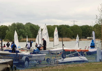 Piccole barche a vela e persone accanto a un lago al Tiny Wagon, Marina Parcs Almere, Paesi Bassi.
