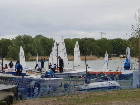 Piccole barche a vela e persone accanto a un lago al Tiny Wagon, Marina Parcs Almere, Paesi Bassi.