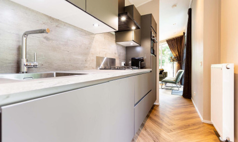Modern kitchen area in Silva Wellness Lodge at Landgoed de Scheleberg, Netherlands, with sleek décor and lighting.