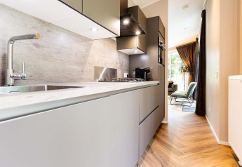 Modern kitchen area in Silva Wellness Lodge at Landgoed de Scheleberg, Netherlands, with sleek décor and lighting.