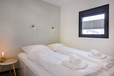 Dormitorio moderno en Houseboat Aqua Dolce en Welcome In - Friesland, Países Bajos, con dos camas individuales.