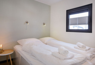 Dormitorio moderno en Houseboat Aqua Dolce en Welcome In - Friesland, Países Bajos, con dos camas individuales.