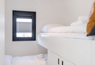 Cabina moderna con letti a castello bianchi e finestra su Houseboat Aqua Dolce, Friesland, Paesi Bassi.