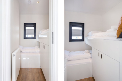 Zona notte moderna con letti a castello su Houseboat Aqua Dolce a Welcome In - Friesland, Paesi Bassi, arredo bianco.