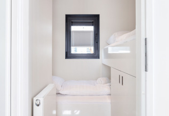 Brillante y moderna zona de descanso con ventana y literas en Houseboat Aqua Dolce, Friesland, Países Bajos.