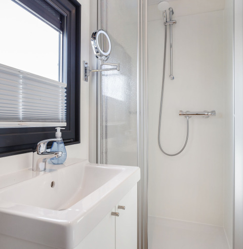 Bagno moderno sulla Houseboat Aqua Dolce in Frisia, Paesi Bassi, con doccia, lavandino e finestra.