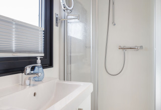 Bagno moderno sulla Houseboat Aqua Dolce in Frisia, Paesi Bassi, con doccia, lavandino e finestra.