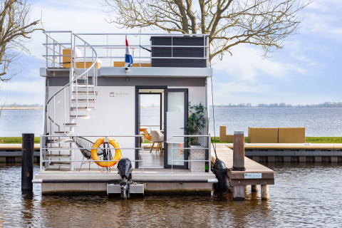 Houseboat Aqua Dolce presso Welcome In - Friesland, Paesi Bassi, con terrazza moderna e vista lago.