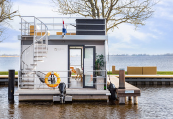 Houseboat Aqua Dolce presso Welcome In - Friesland, Paesi Bassi, con terrazza moderna e vista lago.