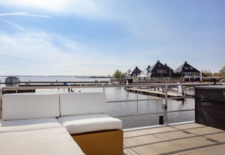 Blick von Hausboot Aqua Dolce bei Welcome In - Friesland auf einen Yachthafen mit modernen Gebäuden.