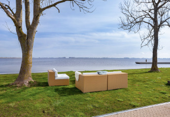 Salon extérieur avec canapés modernes sur pelouse au bord du lac à Houseboat Aqua Dolce, Friesland, Pays-Bas.